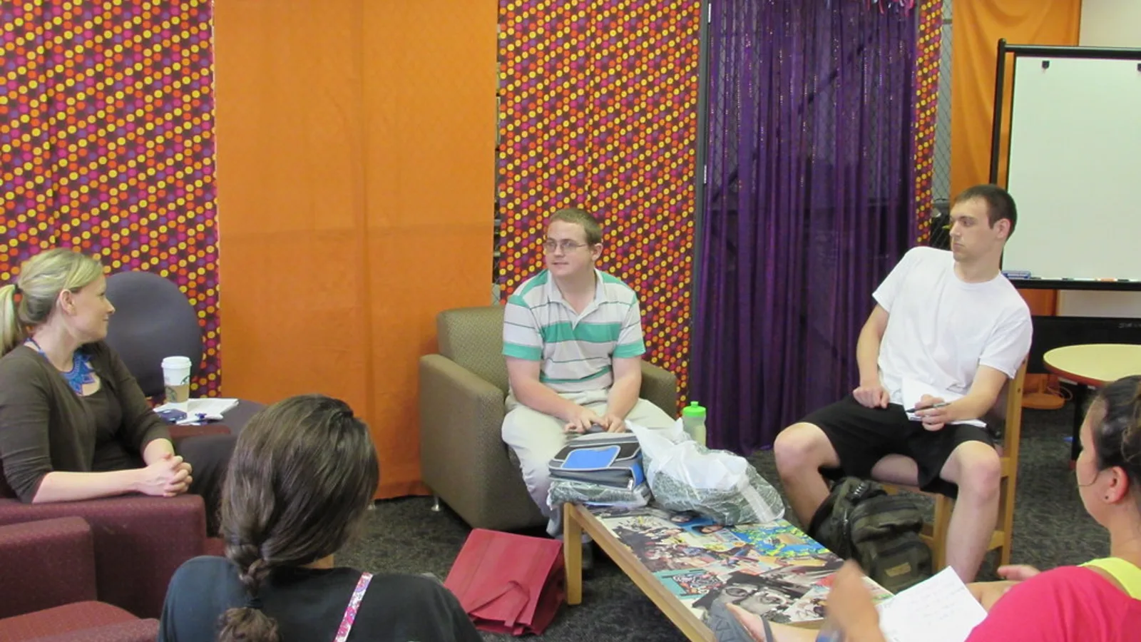 Two adults talking across a table with notebooks, showing how long it takes to learn Spanish in practice