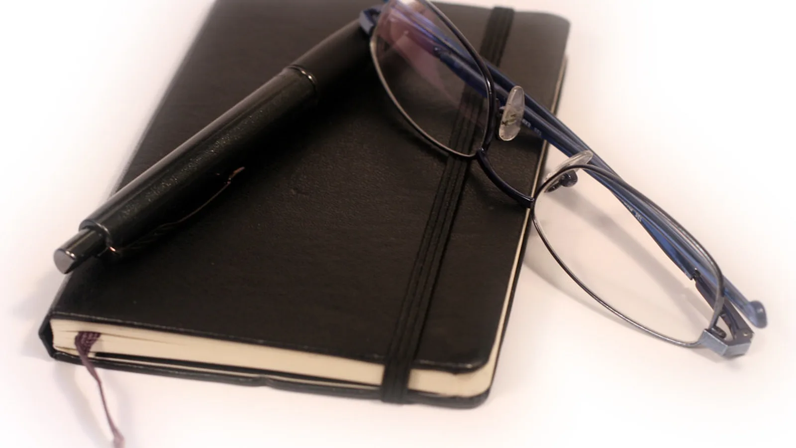 Open Spanish workbook on a desk next to a paper planner and pen