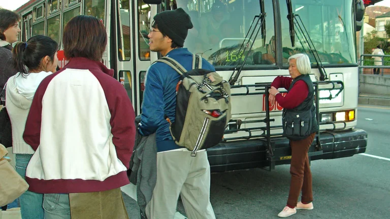 Passenger squeezing past standing riders on a crowded bus, illustrating how to say excuse me in Spanish